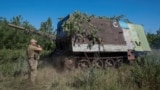 Украинский военный бронеавтомобиль буксирует гаубицу «Мста-Б» по дороге в Торецк на востоке Донецкой области, 24 июня 2024 года