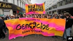Учасники пропалестинської демонстрації несуть банер із написом шведською «Ні геноциду», вимагаючи виключення Ізраїлю із конкурсу «Євробачення». Мальме, Швеція. 9 травня 2024 року