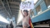 Aktivistkinja feminističke grupe FEMEN protestuje protiv surogat majčinstva u Ukrajini, Kijev, 2011. godine. Fotografija sa ovog protesta pojavila se na proruskoj izložbi "Zarobljena NATO tehnika" na jugu Srbije u junu 2024. 