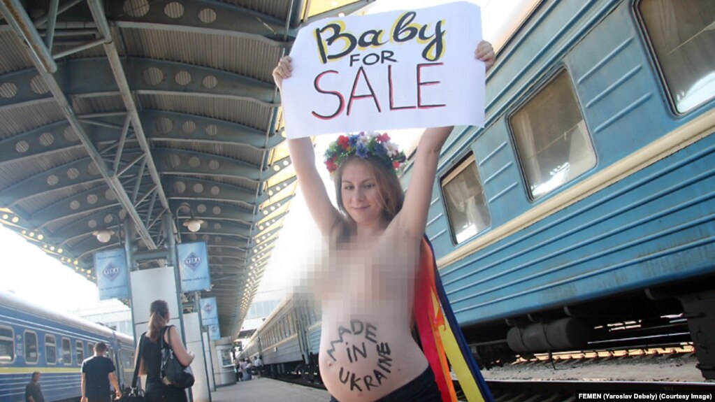 Aktivistkinja feminističke grupe FEMEN protestuje protiv surogat majčinstva u Ukrajini, Kijev, 2011. godine. Fotografija sa ovog protesta pojavila se na proruskoj izložbi "Zarobljena NATO tehnika" na jugu Srbije u junu 2024.