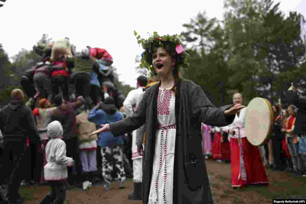 A woman wearing traditional Russian folk clothing dances while celebrating the summer solstice in the village of Okunevo, about 200 kilometers northeast of the Siberian city of Omsk, Russia.