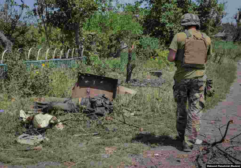 Ukrán katona egy orosz katona holtteste mellett&nbsp;Neszkucsnéban.&nbsp;A Donyeck keleti részén fekvő négy településből itt folytak a legsúlyosabb harcok.&nbsp;Ukrajna hat katonát vesztett itt