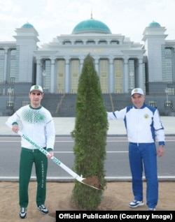 O altă imagine publicată de presa de stat din Turkmenistan, tot pe18 martie, îl arată pe Serdar și pe tatăl său, Gurbangulî Berdîmuhamedov, plantând un arbust în fața unei clădiri guvernamentale.