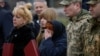 Ukrainian soldiers and relatives of fallen defenders react as they attend a ceremony to mark the first anniversary of the liberation of the town of Bucha on March 31.