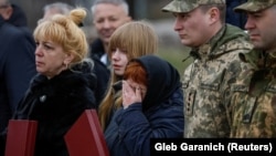 Ukrainian soldiers and relatives of fallen defenders react as they attend a ceremony to mark the first anniversary of the liberation of the town of Bucha on March 31.