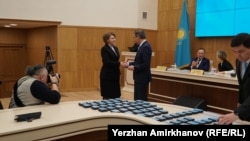 Татьяна Савельева ОСК басшысы Нұрлан Әбдіровтен депутат куәлігін алып тұр. Астана, 28 наурыз 2023 жыл. 