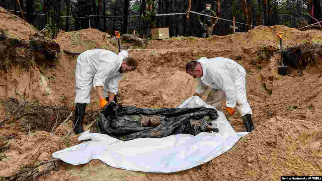 The exhumation of the body of a Ukrainian soldier with his hands tied behind his back in a mass grave near Izyum, in the Kharkiv region, on September 16, 2022.