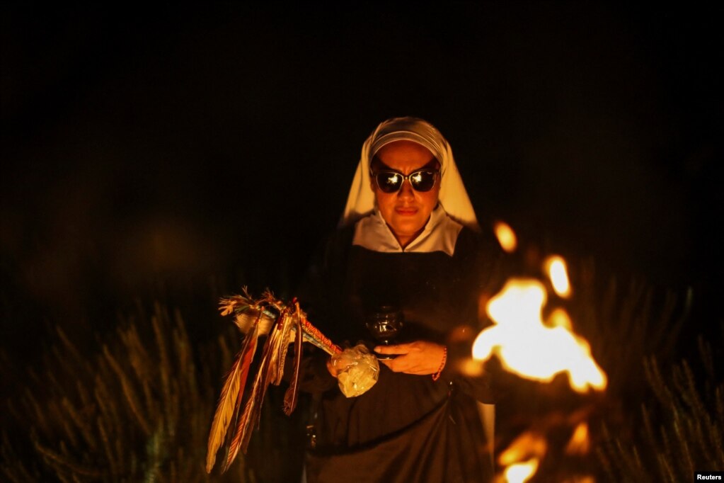 Rituali i hënës së plotë në fermën e Motrave të Luginës në periferi të një fshati në Meksikën qendrore, 2 shtator 2023. Nën çdo hënë të plotë, një grup grash me zakone murgeshash sillen rreth një zjarri të zhurmshëm, pastrohen me sherebelë të djegur dhe bëjnë falënderime për hënën, kafshët dhe bimët. Pavarësisht veshjes së tyre, gratë nuk janë katolike apo të ndonjë feje tjetër.