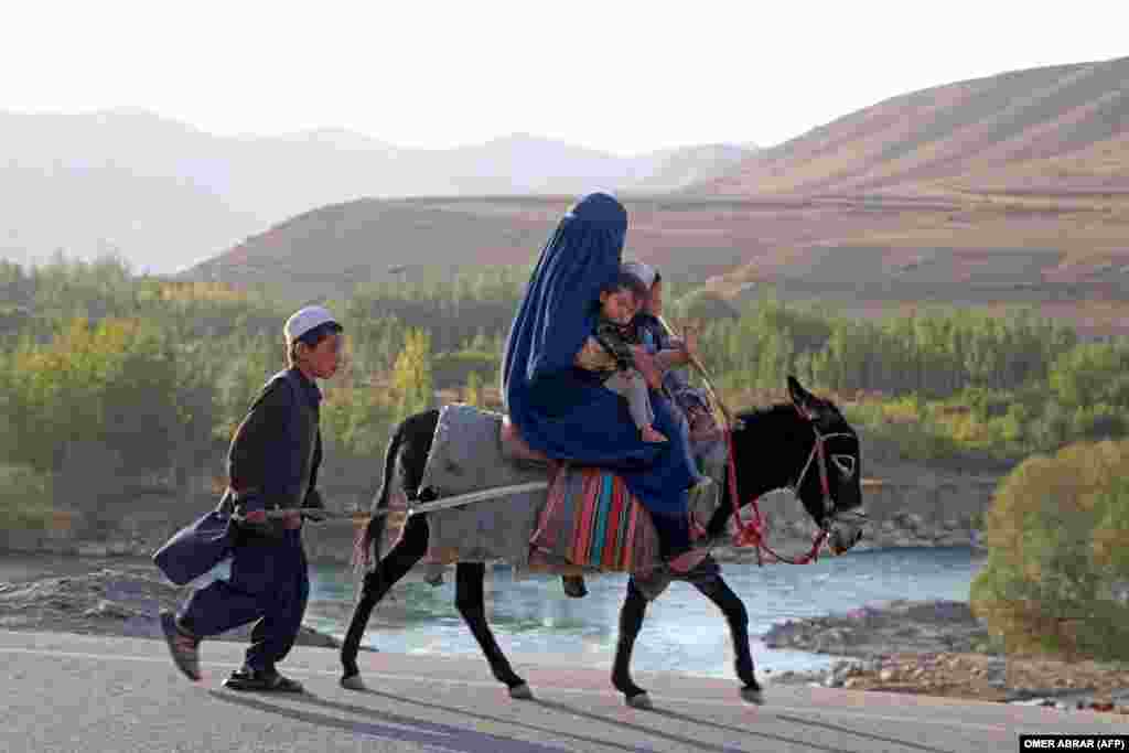 An Afghan woman with children ride a donkey in the Kishim district of Badakhshan Province.