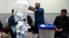 Election workers empty a ballot box in Iran's presidential election. 