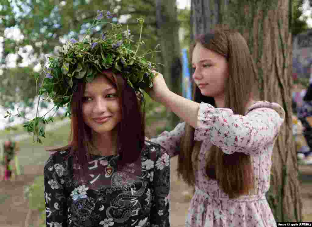 Alina from Lviv adjusts the wreath of her friend Zarina from the Mykolayiv region. Alina says the skill of weaving wreaths from flowers and greenery is generally handed down from mother to daughter. &ldquo;You need some experience, but generally it works out one way or another.&quot; &nbsp;