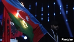Armenia - A protester burns the Azerbaijani flag during the opening ceremony of the European Weightlifting Championship in Yerevan, April 14, 2023.