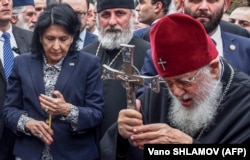 Georgian President Salome Zurabishvili (left) with Georgian Orthodox Patriarch Ilia II take part in a prayer as they mark the Day of National Unity in Tbilisi in 2019.