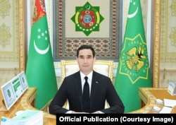 Slika predsjednika Berdimuhamedova od 7. februara. Grb Turkmenistana iznad predsjednikove glave je u oštrom fokusu dok ostali pozadinski motivi nisu toliko izoštreni.
