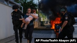 Ізраїльська поліція допомагає евакуюватися жінці з малою дитиною з місця ракетного удару в Ашкелоні, Ізраїль, 7 жовтня 2023 року
