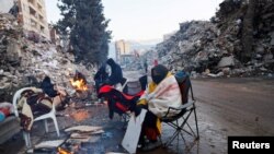 Tűznél melegedő túlélők Törökországban 2023. február 13-án
