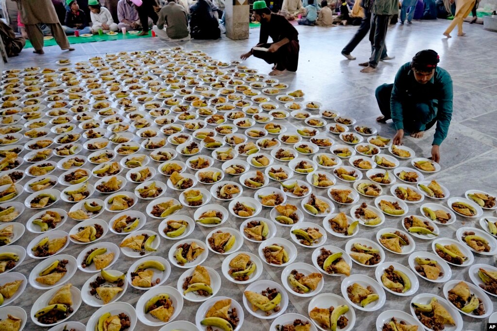 Vullnetarët organizojnë pjata me ushqim që do t'u shpërndahen njerëzve për iftar gjatë muajit të shenjtë të Ramazanit, në Lahore, Pakistan, 12 mars 2024.