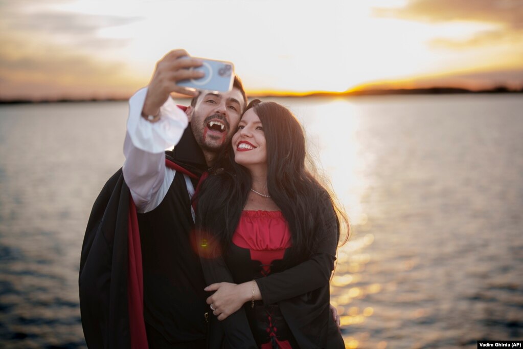 Un uomo vestito da vampiro più famoso del mondo, il Dracula di Bram Stoker, ispirato a un principe medievale rumeno e al Castello di Bran, a nord di Bucarest, si fa un selfie con una donna.