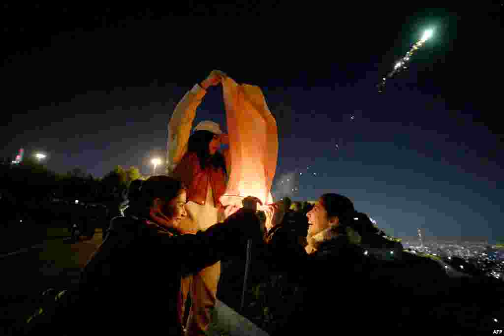 Iranian women light a lantern on the eve of the Wednesday Feast&nbsp;in Tehran on March 12, ahead of Norouz, the Persian New Year, which begins on March 20 and coincides with the first day of spring. The celebrations have arrived in an atmosphere of growing frustration with the clerical establishment as a historically low turnout marred a March 1 parliamentary election. &nbsp;