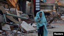 Një vajzë e vogël duke ecur afër zonave të shkatërruara nga tërmeti në Turqi.
