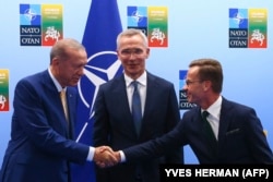 Erdogan și premierul suedez Ulf Kristersson își strâng mâinile în apropierea secretarului general NATO Jens Stoltenberg înainte întâlnirii dintre ei, în ajunul summitului NATO din Vilnius, pe 10 iulie.