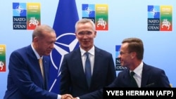 Presidenti i Turqisë, Recep Tayyip Erdogan, dhe kryeministri i Suedisë, Ulf Kristersson, shtrëngojnë duart para sekretarit të përgjithshëm të NATO-s, Jens Stoltenberg, para një takimi në samitin e NATO-s në Vilnius, 10 korrik 20223.