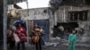 Një grua dhe tre fëmijë duke kaluar afër ndërtesave të shkatërruara në Rafah, në jug të Rripit të Gazës më 20 dhjetor 2023. 