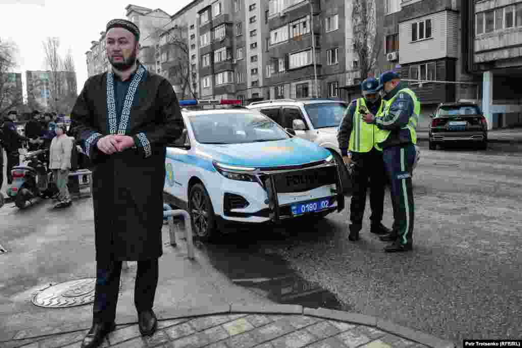 Мужчина стоит у полицейского автомобиля неподалёку от Центральной мечети. Во время праздничного намаза сотрудники полиции следили за порядком и регулировали движение на дорогах