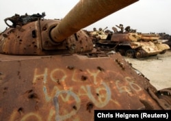 A destroyed Iraqi tank from the first Gulf War marked with "DU," indicating it has been hit with depleted uranium and is contaminated. The photo was taken at a scrapyard in Kuwait in 2002.