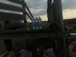 Drinking water and other essentials are brought to the makeshift encampment.