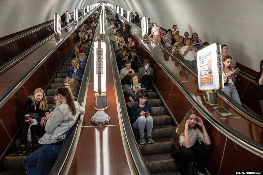 Njerëzit strehohen në një stacion metroje gjatë një sulmi rus me raketa në Kiev.