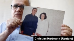 Taghi Ramahi, husband of Narges Mohammadi, poses with an undated photo of himself and his wife, during an interview at his home in Paris on October 6.
