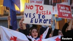 "Орусияга - жок, Европага - ооба" деген жазуусу бар ураанды көтөргөн митинг катышуучусу. 15-апрель, 2024-жыл.