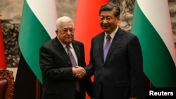Palestinian President Mahmud Abbas (left) shakes hands with China's President Xi Jinping after a signing ceremony in the Great Hall of the People in Beijing on June 14. 