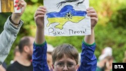 Дете държи рисунка на картата на Украйна с надпис "Долу ръцете!"