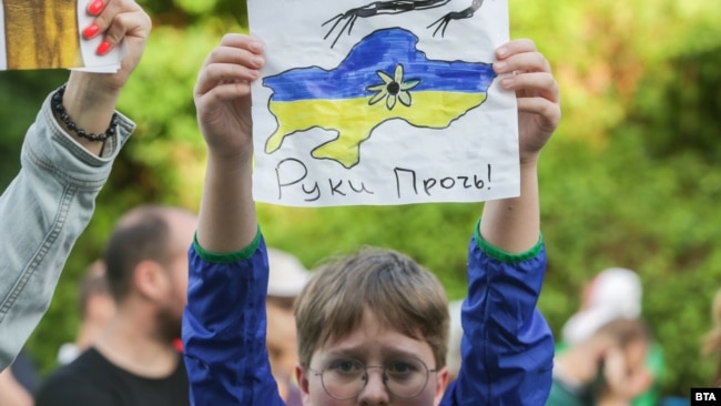 Дете държи рисунка на картата на Украйна с надпис "Долу ръцете!"