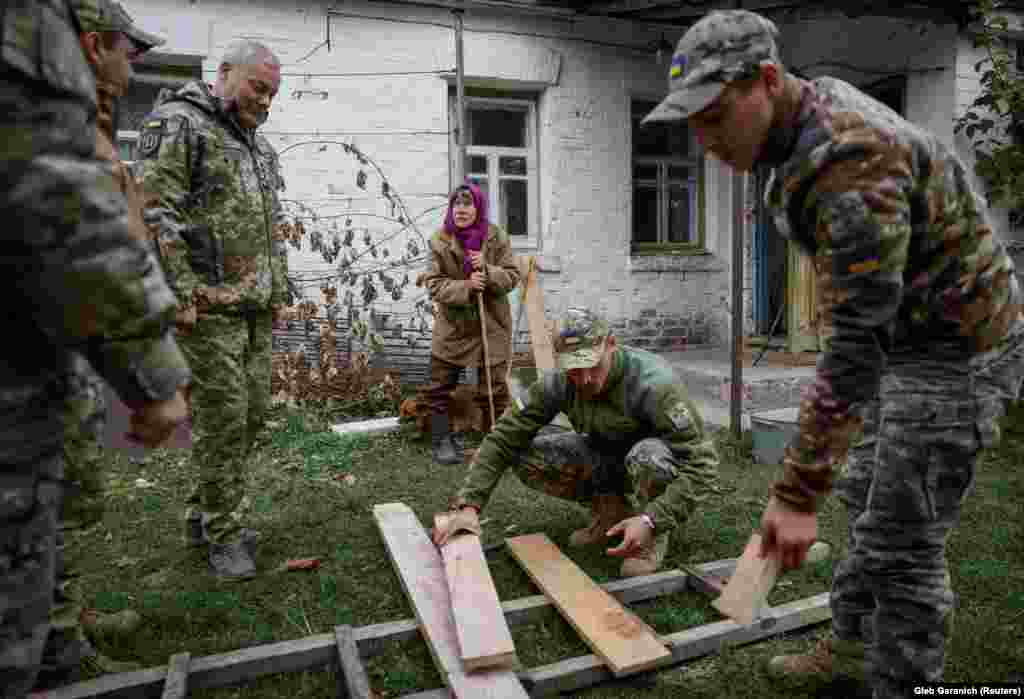 Безнощенко спостерігає, як солдати ремонтують її будинок. За даними 2013 року, які оприлюднив український уряд, у зоні відчуження проживає від 200 до 2 000 осіб.