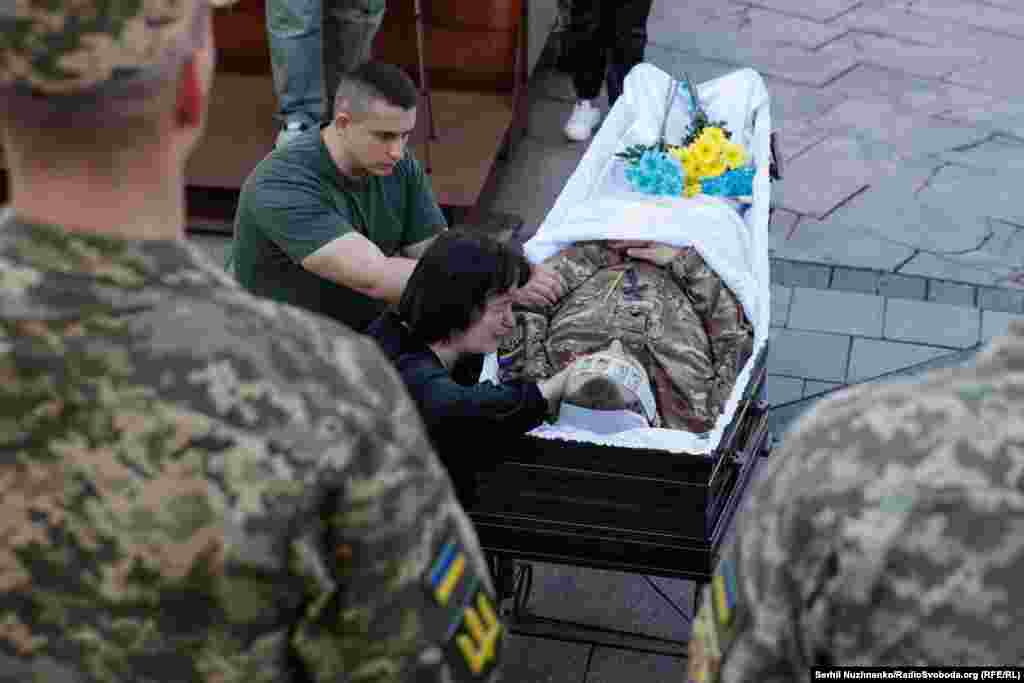 The grieving mother of Serhiy Konoval kneels&nbsp;at her son&#39;s coffin.