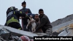  Спасители и доброволци вадят дете под останките от жилищна постройка в Славянск след съветската офанзива от 14 април 