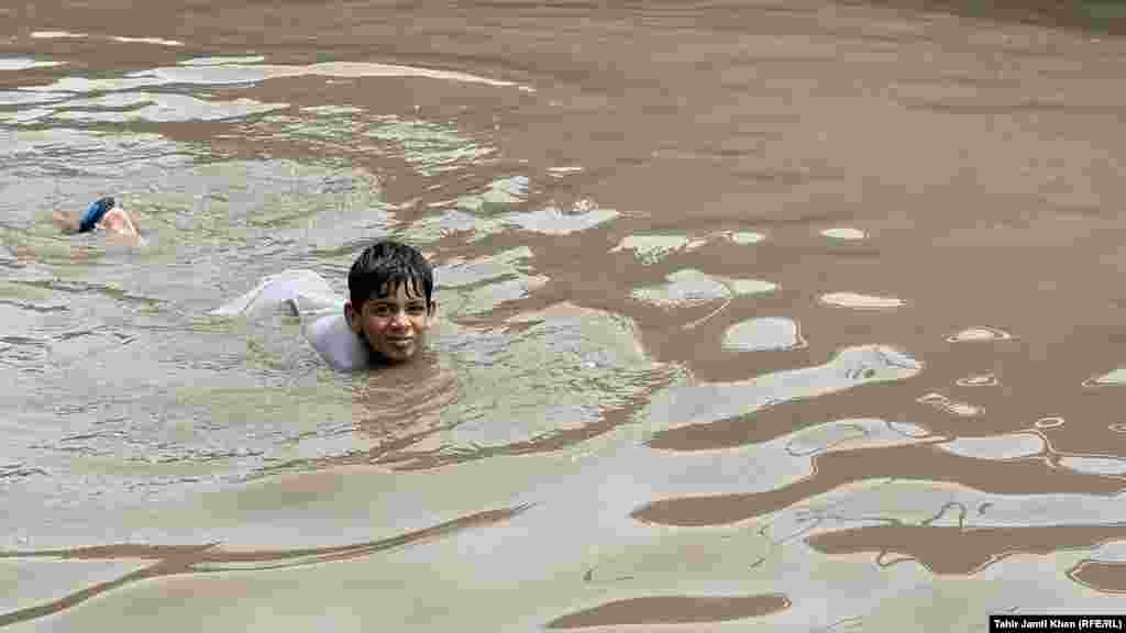 A child swims in the floodwaters. More than 2,200 homes have been damaged across Pakistan since July 1, when the monsoon rains began, the National Disaster Management Authority said in a report.