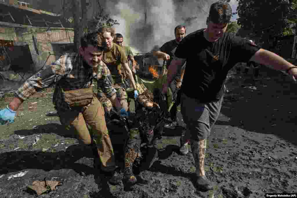 Paramedics carry the body of a man who was killed.