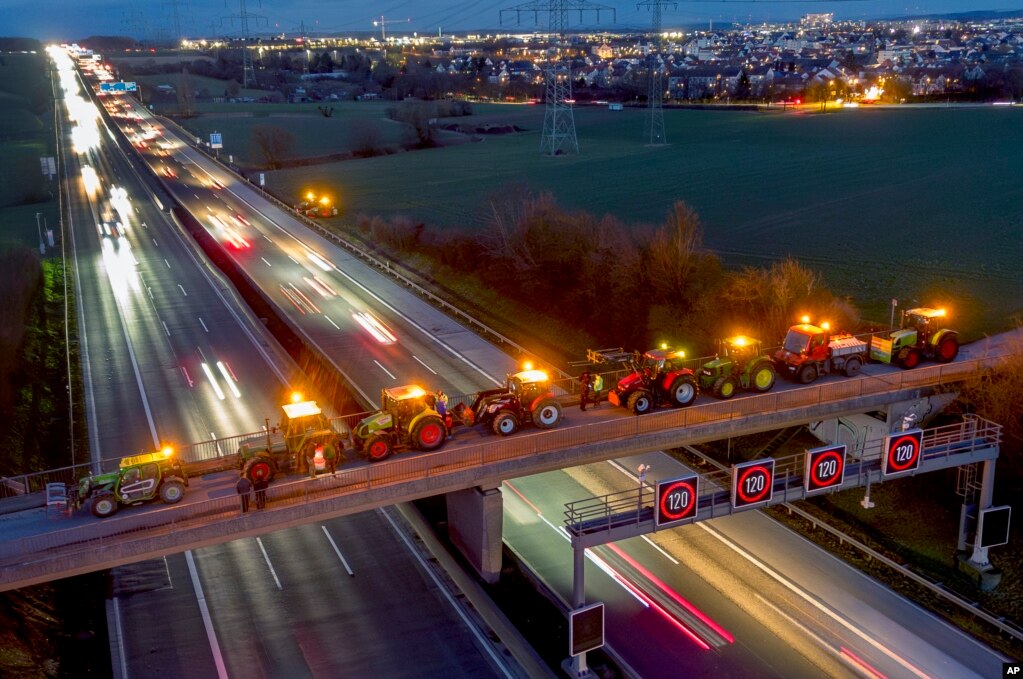 Traktorë të parkuar në një urë mbi një autostradë në Frankfurt, Gjermani.