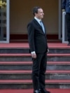 Kryeministri në detyrë i Kosovës, Albin Kurti, duke pritur - mes flamurit të Bashkimit Evropian dhe atij të Kosovës - para hyrjes së ndërtesës së Qeverisë së Kosovës, në Prishtinë.