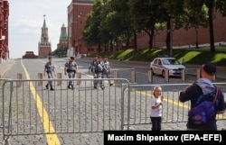 Люди у шлагбаума, преграждающего путь к Красной площади в Москве, 25 июня 2023 года