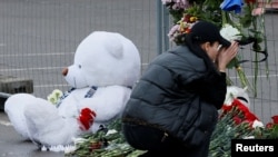 Prolaznici ostavljaju cvijeće i mole se ispred dvorane u Moskvu u kojoj se desio napad