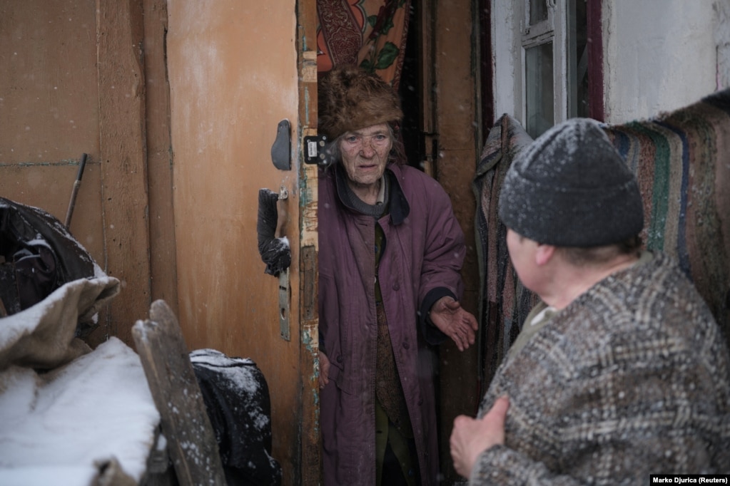 Olha (right) informs her 89-year-old neighbor, Lidia Chynyakova, that she must immediately leave her home on February 12.  As Russia gains ground around Bakhmut -- less than 15 kilometers to the east -- Kyiv is urging all residents in Chasiv Yar to evacuate.