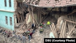 Rescuers and volunteers help clear the rubble at a boarding school in Odorheiu Secuiesc, Romania, that collapsed on December 18.