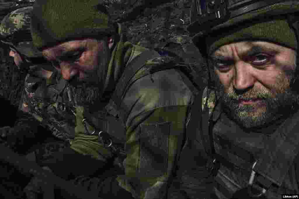 Ukrainian soldiers sit in a trench along the front line. Russian forces and mercenaries have been unable to encircle the outnumbered and outgunned Ukrainian defenders. &nbsp;