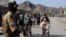 A Taliban fighter stands guard as Afghan boys help men in wheelchairs following an incident of gunfire at the Torkham border crossing between Afghanistan and Pakistan on February 20.