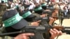 Pripadnici militantne grupe Hamas marširaju sa puškama AK 47 tokom skupa Hamasa u kampu Bureij u Pojasu Gaze 5. marta 2004.
